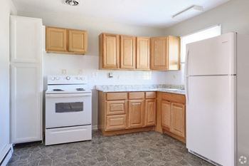 a kitchen with white appliances and wooden cabinets